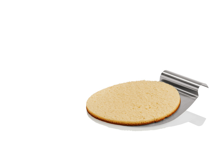 Une couche de gâteau sur un couteau à gâteau en métal