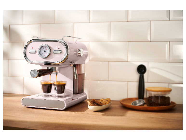 Une machine à expresso Silvercrest rose sur un comptoir en bois.
