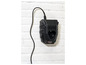 Un chargeur Parkside noir pour batteries sur un mur blanc.