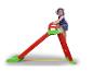 Petite fille sur un toboggan rouge et vert pour enfants.