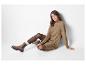 Femme assise portant une robe en tricot marron et des bottes marron.