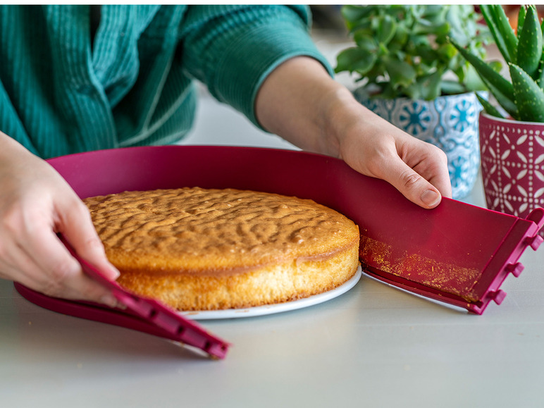 Un gâteau cuit est retiré d'un moule rose.
