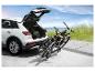 Deux vélos sur un porte-vélos à l'arrière d'une voiture blanche.