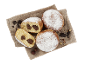Beignets fourrés au chocolat et saupoudrés de sucre glace, servis sur un tissu en lin avec des noisettes.