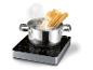 Des spaghettis bouillant dans une casserole sur une plaque à induction.