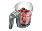 Une balance de cuisine grise Silvercrest avec un gobelet doseur en verre rempli de fraises, framboises et myrtilles.