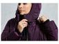 Une femme porte une veste d'hiver violette avec une capuche.