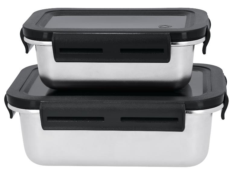 Deux boîtes alimentaires en acier inoxydable avec couvercles et fermoirs noirs, empilées sur fond blanc.