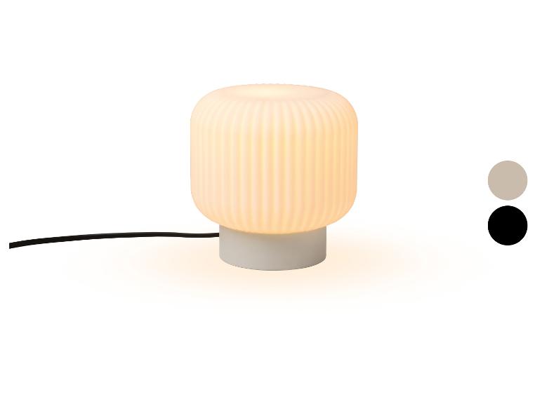 Lampe de table avec abat-jour blanc nervuré et base grise, avec échantillons de couleur.