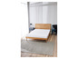 Un lit avec un matelas et un tapis dans une chambre moderne.