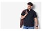 Homme en chemise noire avec veste marron sur l'épaule.