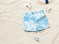 Short de bain bleu avec motif nuage sur le sable.