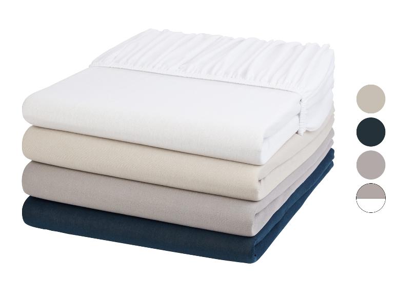 Draps-housses empilés, couleurs neutres.
