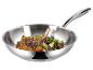 Poêle à frire en acier inoxydable avec côtelettes d'agneau et herbes.