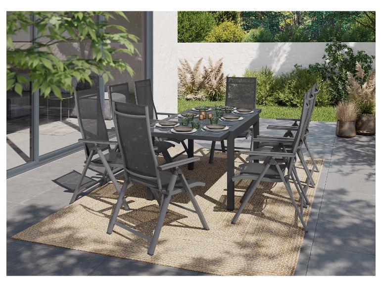 Ensemble de jardin avec table et chaises grises sur une terrasse avec tapis.