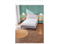 Un lit gris avec un matelas blanc dans une chambre avec un plancher en bois.