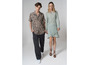 Un homme et une femme en tenue décontractée, il porte une chemise à motif et elle une robe verte.