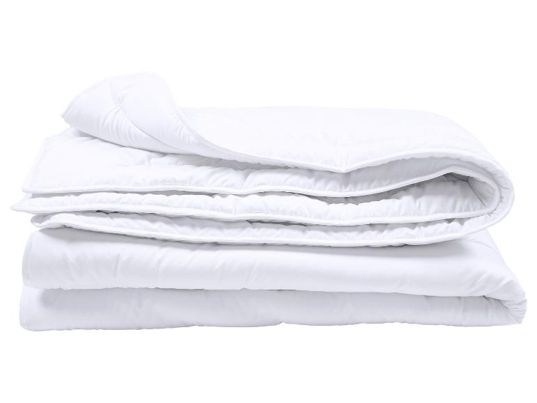 Couette blanche pliée avec surpiqûres sur fond blanc