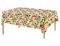 Nappe à motif floral tropical vif sur une table en bois.