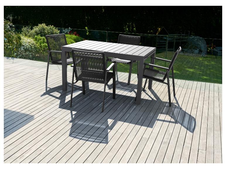 Une table de jardin en bois avec quatre chaises à dossier tressé sur une terrasse en bois.