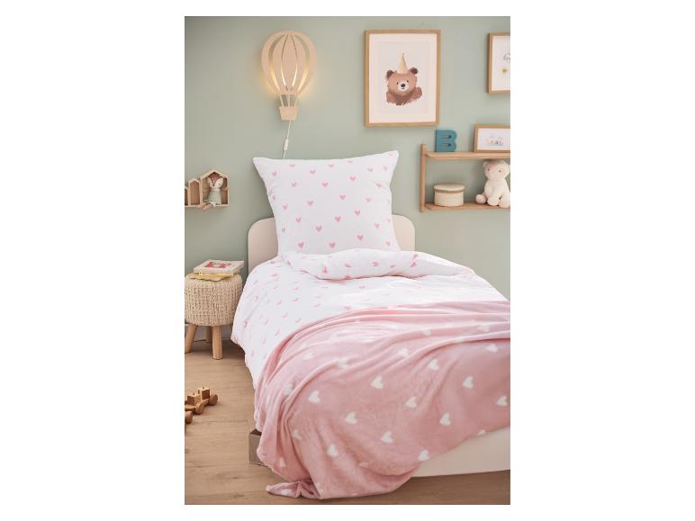 Lit d'enfant avec parure de lit blanche à cœurs roses et couverture rose