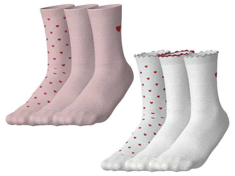 Deux ensembles de chaussettes, un rose à cœurs et un blanc à cœurs et bords volantés.