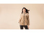 Une femme porte une veste beige doublée de fausse fourrure.
