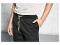 Pantalon de survêtement noir avec des accents jaunes.