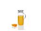 Une carafe en verre avec du jus d'orange et deux tranches d'orange.
