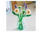 Un bouquet de fleurs jouets dans un vase en verre, avec des marguerites blanches et de la lavande violette.