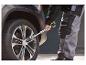 Clé télescopique pour roues PARKSIDE® en cours d'utilisation sur une voiture.