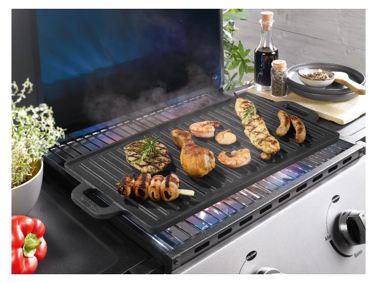 Plaque de grill avec diverses viandes et fruits de mer, y compris poulet, crevettes et saucisses.