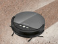 Un aspirateur robot noir Silvercrest sur un tapis.