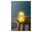 Une lampe de nuit jaune avec Tweety Bird sur une table brun foncé.
