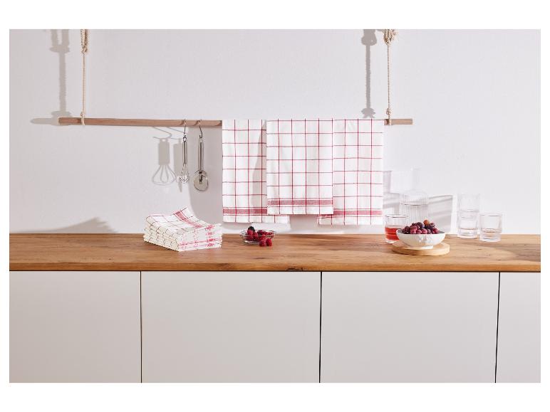 Des torchons à carreaux rouges accrochés à une barre en bois