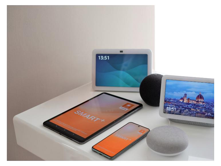 Appareils de maison intelligente, y compris des écrans intelligents, une tablette et un smartphone sur une surface blanche.