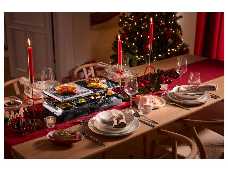 Appareil à raclette avec plaque en pierre et grill sur une table de Noël décorée.