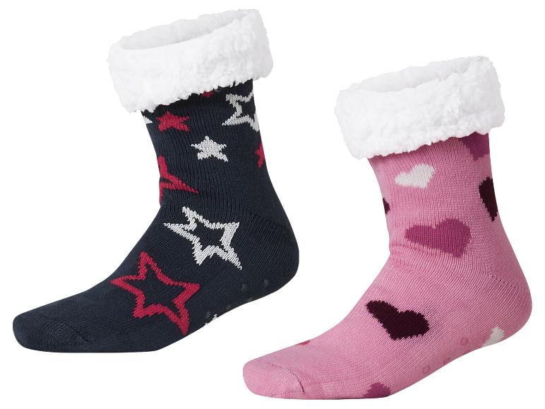 Deux paires de chaussettes d'intérieur, une bleu foncé à étoiles et une rose à cœurs.