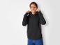 Un enfant porte un sweat à capuche noir et un jean bleu.