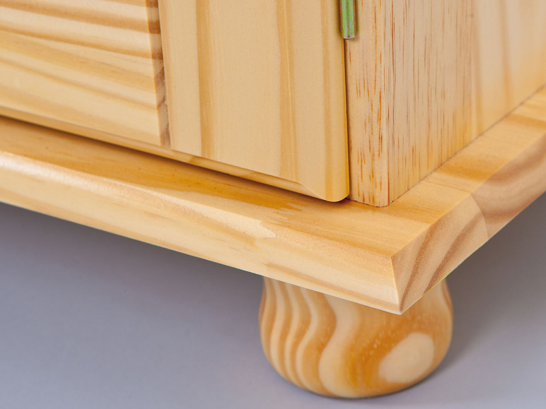 Une armoire en bois avec une porte à panneau et des pieds tournés.