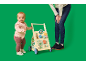 Bébé avec un trotteur et un adulte en arrière-plan