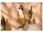 Femme en t-shirt blanc, short jaune et sac de plage avec le mot « Playa ».