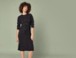 Une femme en robe noire tricotée
