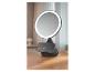 Miroir de maquillage lumineux avec un smartphone en charge sans fil sur sa base.