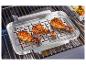 Poulets rôtis sur une grille en acier inoxydable sur un barbecue.