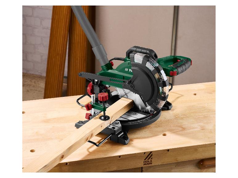 Scie à onglet verte sur un établi en bois avec une pièce de bois en cours de coupe.