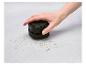 Un aspirateur SilverCrest miniature ramasse des miettes sur une surface.