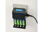 Un chargeur noir avec quatre piles AA de la marque TRONIC, branché sur une prise de courant.