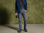 Un homme portant une veste polaire bleue, un pantalon gris et des chaussures de randonnée bleues.
