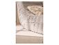 Canapé gris matelassé avec un coussin décoratif beige.